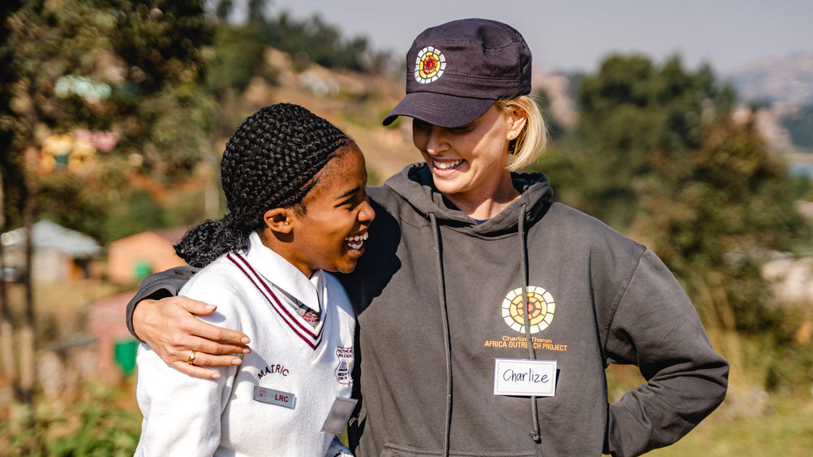 Charlize Theron posing with a schoolgirl in Africa