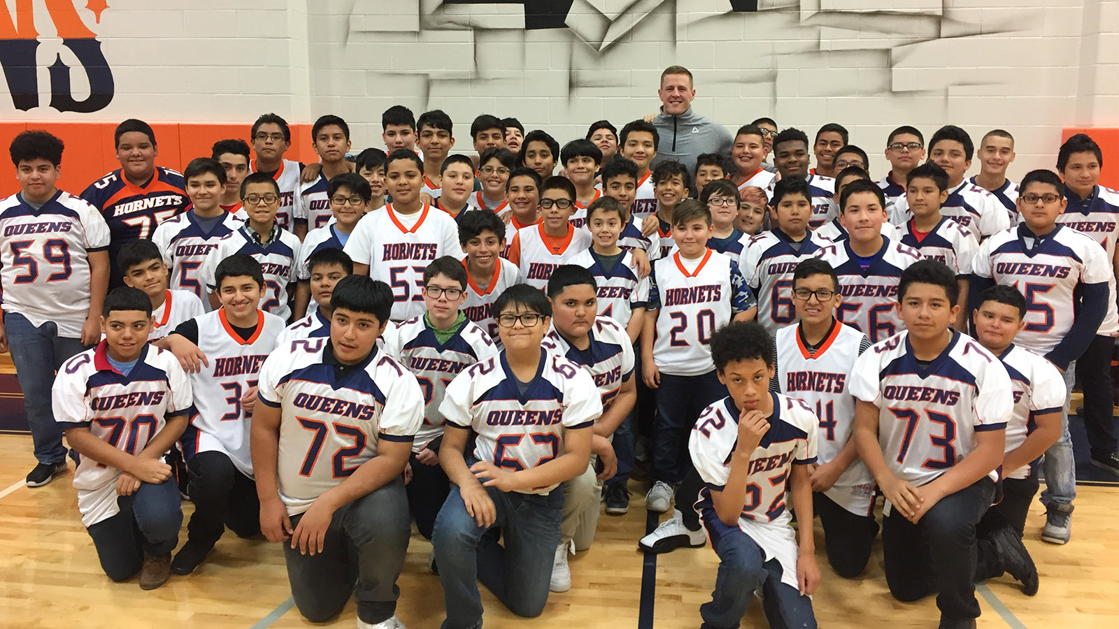 Justin J. Watt is surrounded by middle school athletes.