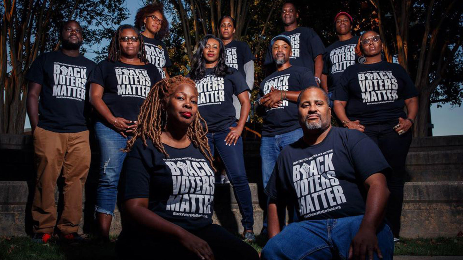 A group of people stand in a group wearing Black Voters Matter t-shirts