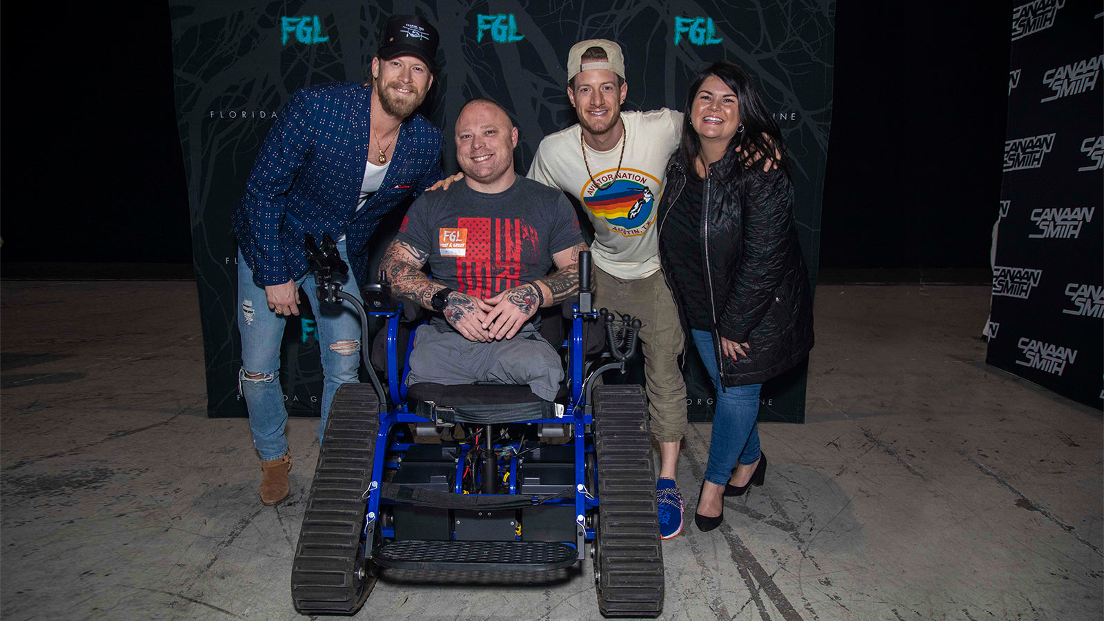 Florida Georgia Line poses for a photo with a man in a wheelchair and woman.