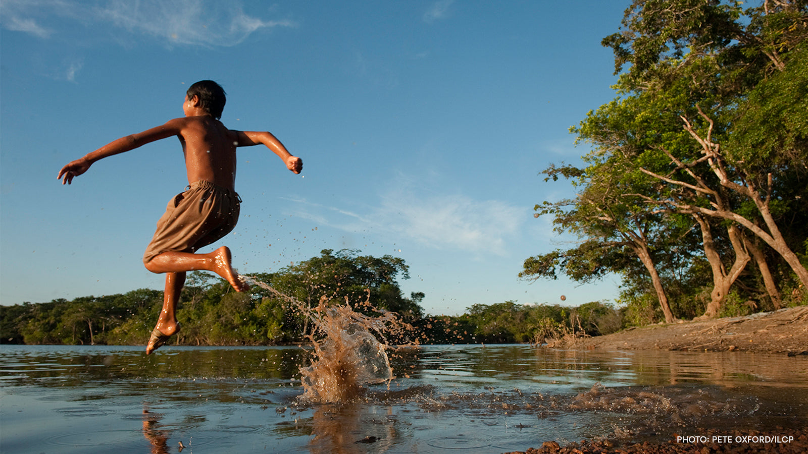 A boy jumping into a water pond; photo credit to Pete Oxford/ILCP.